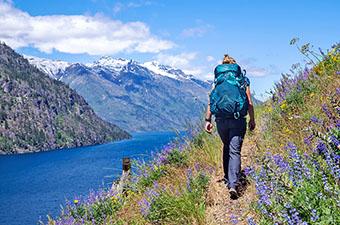 Hiking along lakeshore in mountains (Osprey Eja 58 backpack)