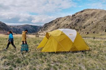 Setting up the REI Base Camp 6 tent in a field while camping in Montana