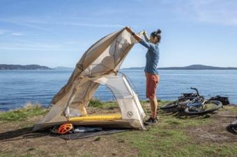 Setting up the big agnes tiger wall bikepack tent next to some water